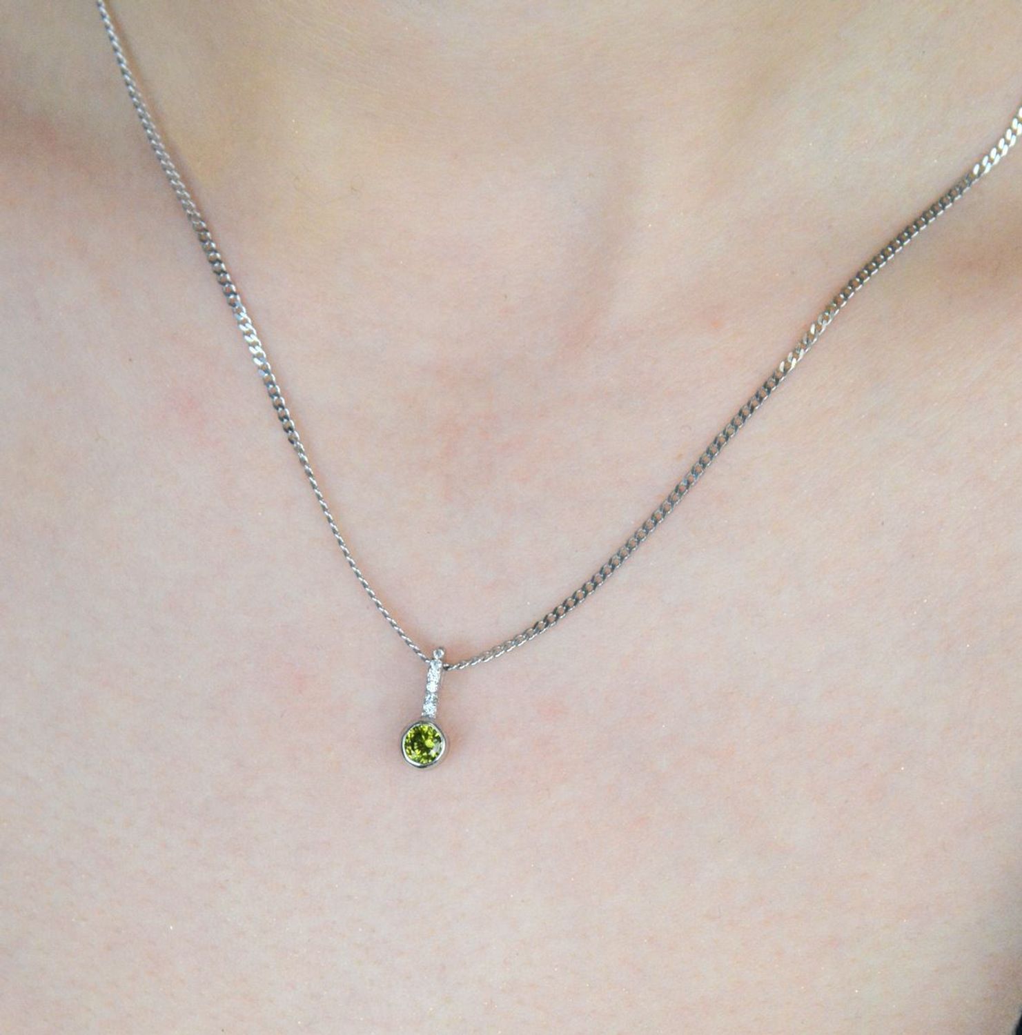 Subtelna srebrna zawieszka z zieloną cyrkonią i białymi zdobieniami u góry. Próba 925, model W 2106, waga 0,70 g, wymiary 1,2 x 0,4 cm. Lekka i elegancka ozdoba..jpg